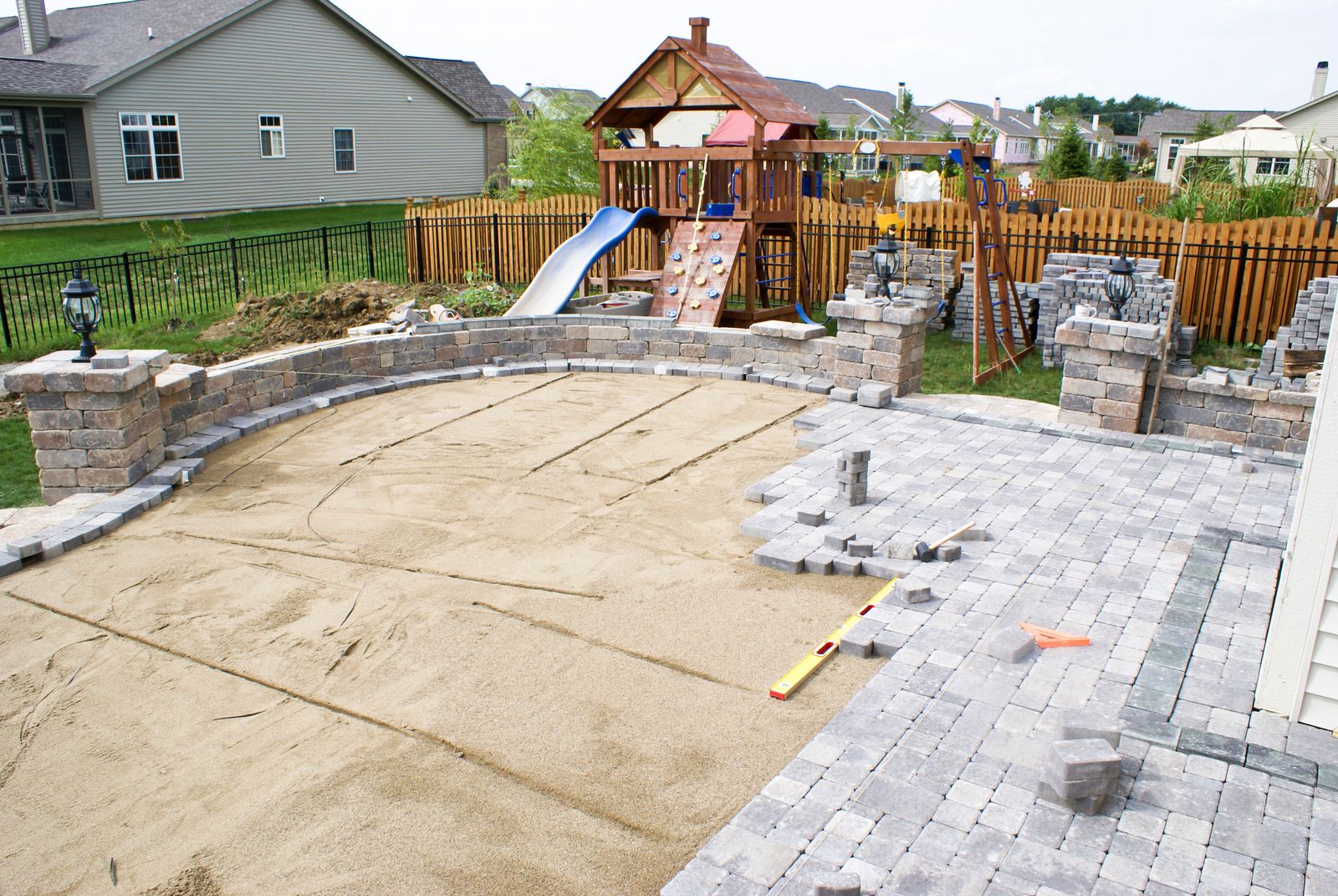 Terrasse im Bau mit Sandbett, gepflasterter Fläche und Natursteinmauer im Garten