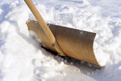 Schneeschieber aus Holz im frisch geräumten Schnee
